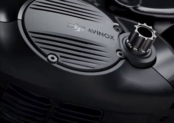 Close-up view of a motorcycle engine cover labeled "DJ AVINOX" with a prominent ribbed design and a metal cap.