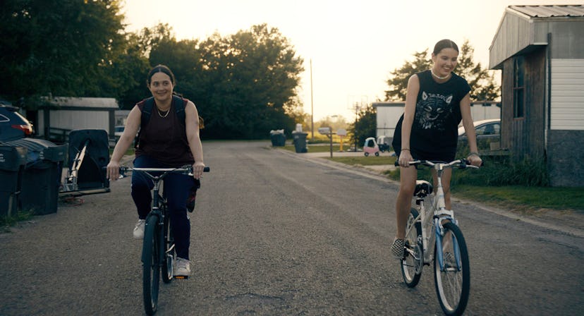 A still from Fancy Dance. The two protagonists ride bikes down the street