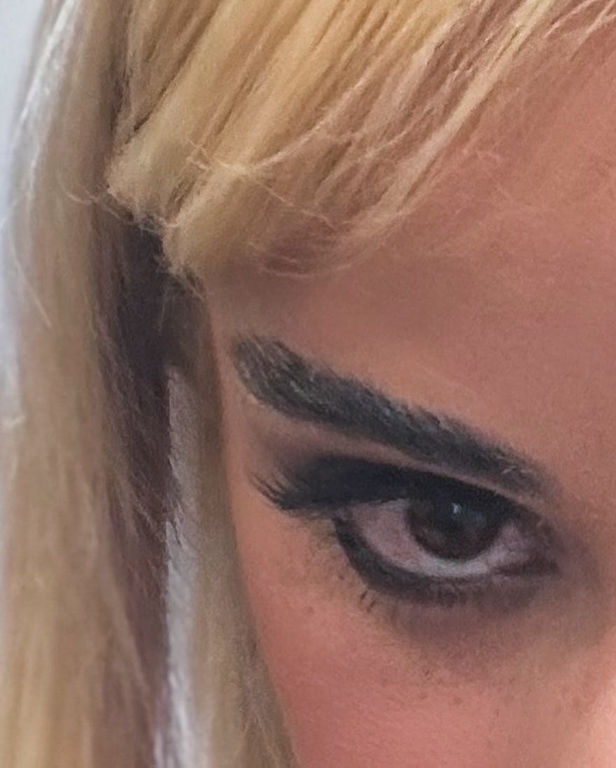 Camila Cabello wears a black dress with cutouts and ballet flats.