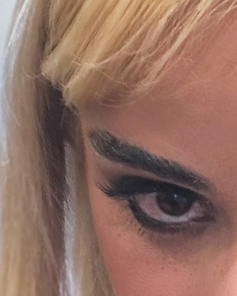 Camila Cabello wears a black dress with cutouts and ballet flats.