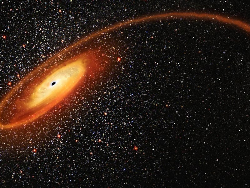 An illustration of a black hole with a glowing accretion disk, with stars in the background