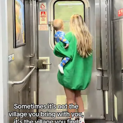 A woman in a green oversized sweater carries a child as they walk toward a train door. The scene conveys warmth and connection. Text overlay shares an inspiring message about community.