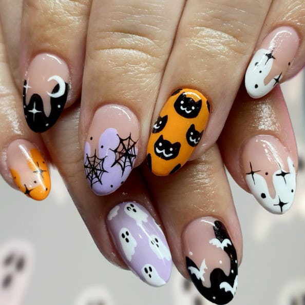 Halloween manicure with cats, moons, and orange and black colors