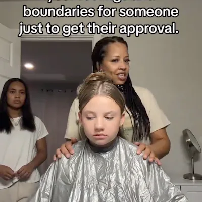 A girl in a salon chair wears a silver cape, looking serious. A woman stands behind her, speaking, while another girl watches in the background.