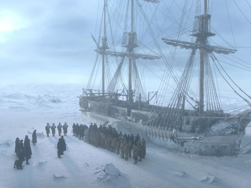 A frozen landscape features an icebound ship with tall masts, while a group of people stands in form...