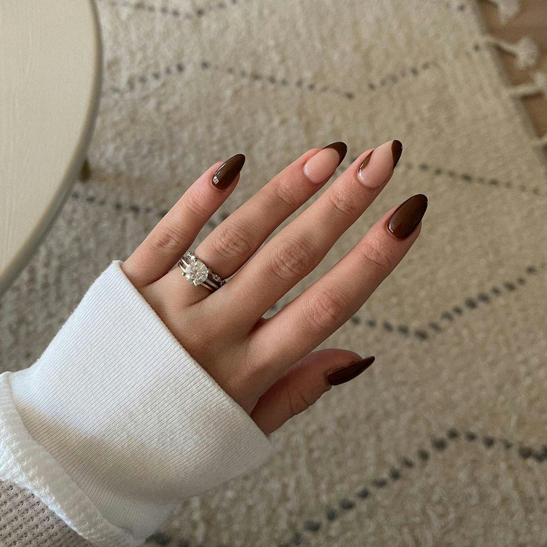 Whimsical dark brown French tip nails are on-trend for fall 2024.