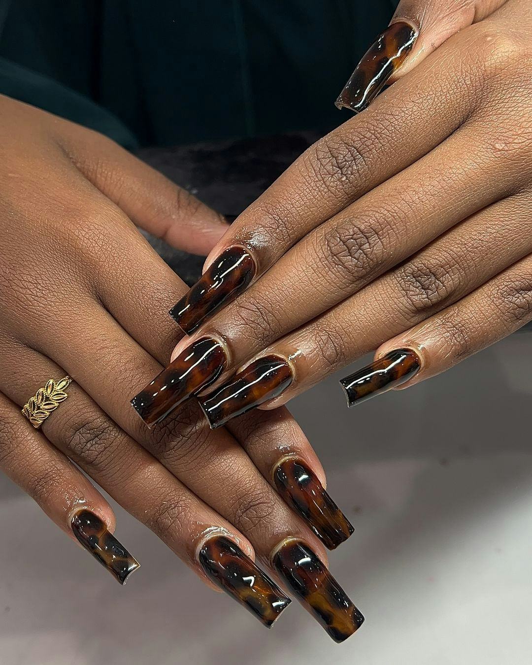 Dark tortoiseshell print nails are on-trend for fall 2024.