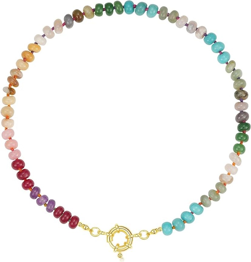 Colorful beaded necklace featuring a variety of stones in a gradient pattern, finished with a gold c...