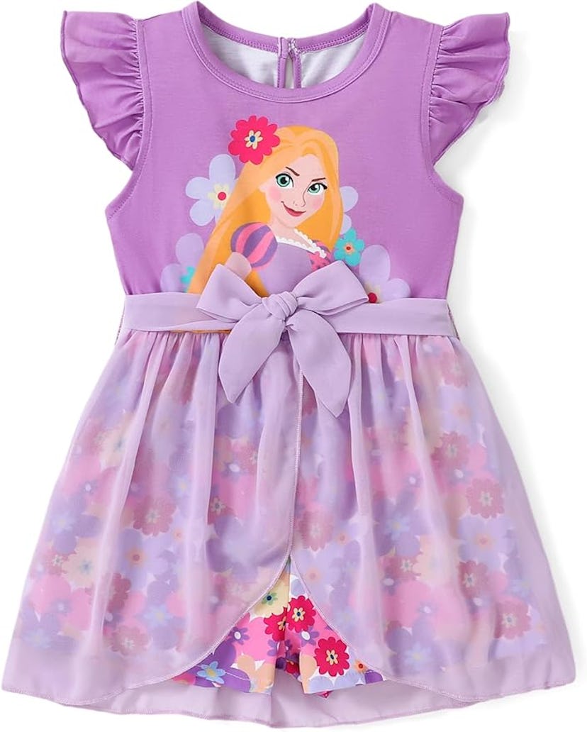 A cute purple dress featuring a character graphic on the bodice, with a floral design on the sheer o...