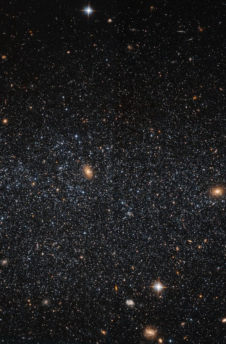 Stars are sprinkled across space. They're gathered loosely, and form a spherical shape. The gaps bet...