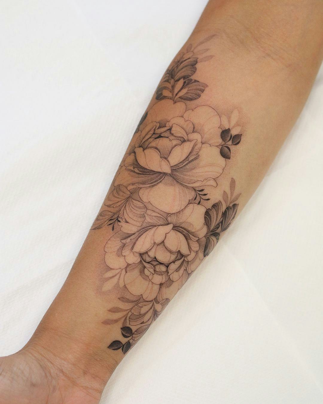 Fine line flower and plant tattoos are on-trend for fall 2024.
