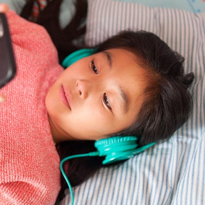 A young girl listens to music.