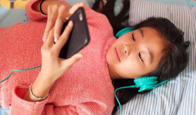 A young girl listens to music.