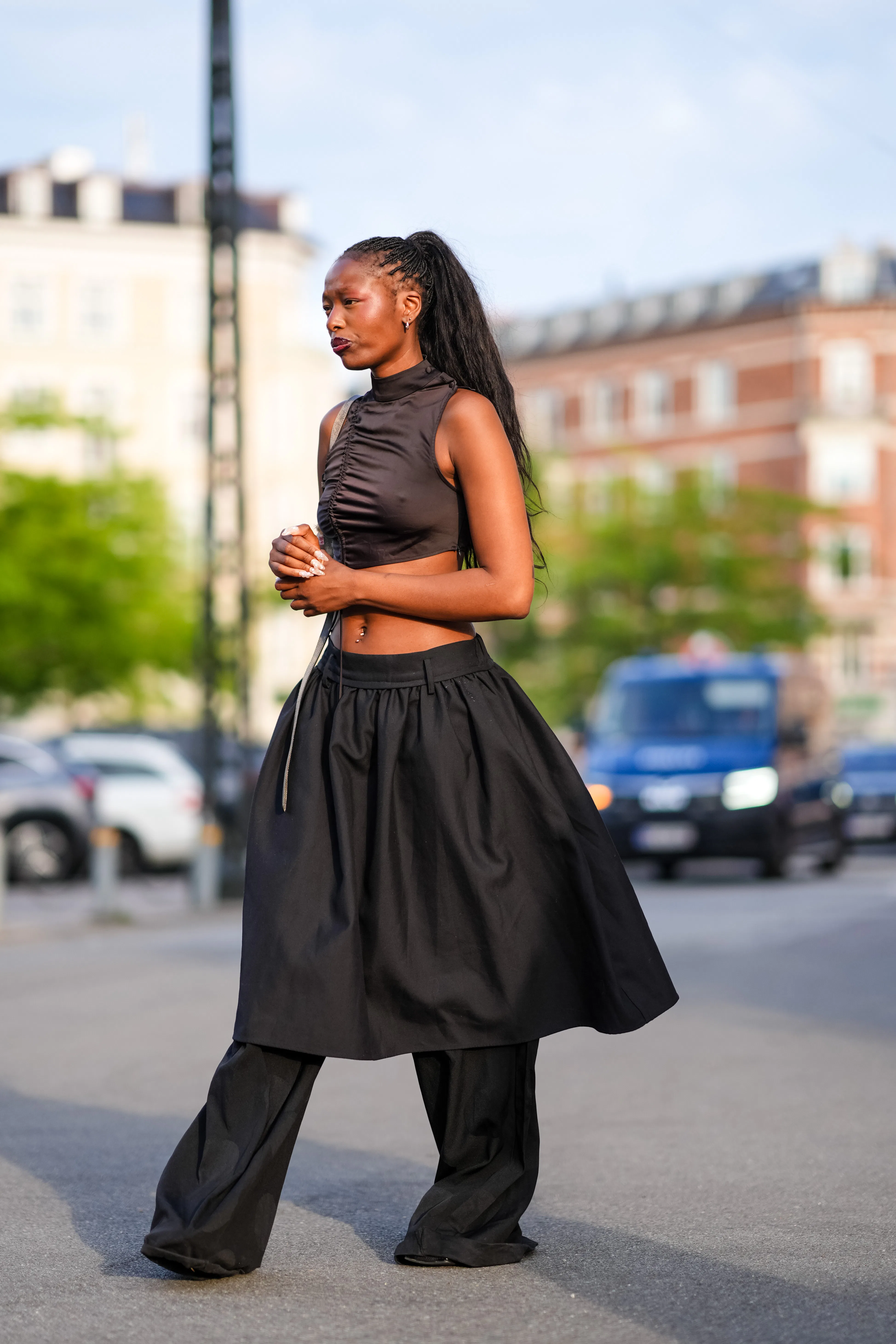 COPENHAGEN, DENMARK - AUGUST 7: A guest wears silver earrings, dark brown sleeveless cropped top, li...
