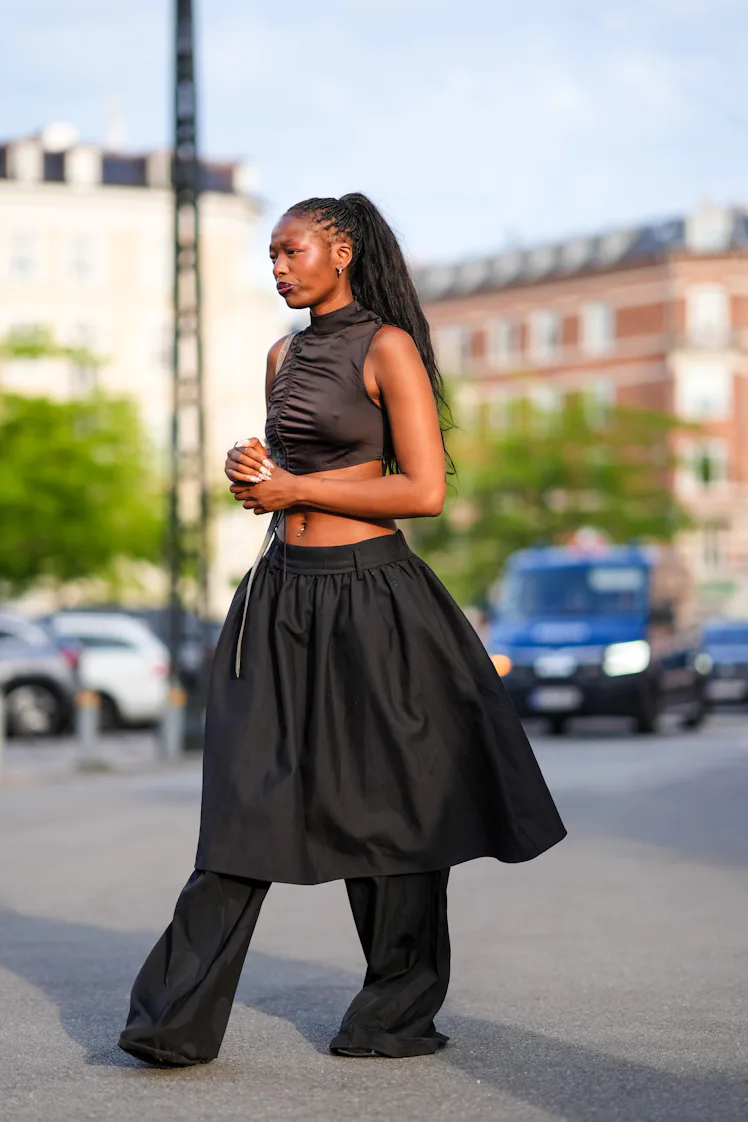 COPENHAGEN, DENMARK - AUGUST 7: A guest wears silver earrings, dark brown sleeveless cropped top, li...