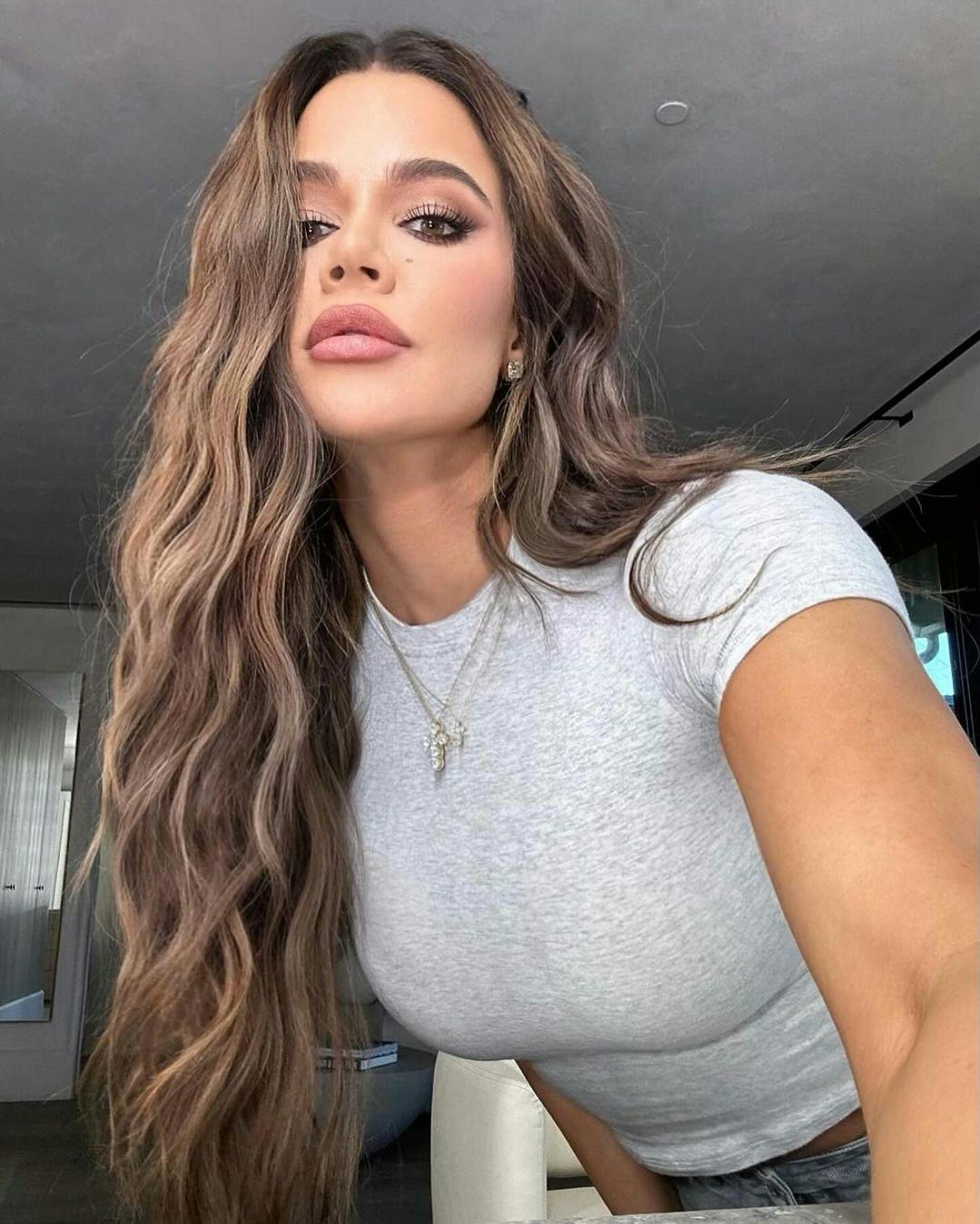 Khloé Kardashian wears a gray T-shirt.