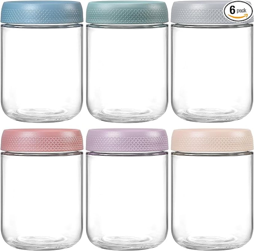 A grid of six glass jars with colorful, textured lids in shades of blue, pink, purple, and beige, sh...