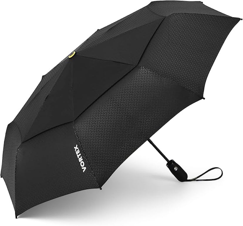 A black umbrella with a textured pattern is opened, showcasing its sturdy frame and brand logo "Vort...