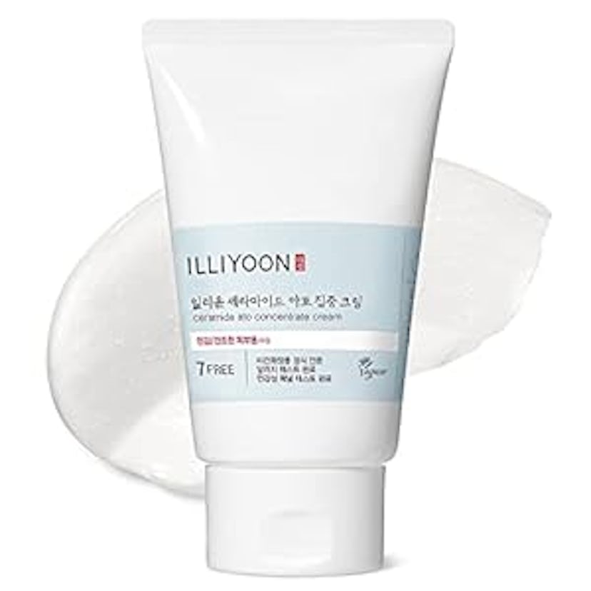 A white squeeze tube of ILLIYOON concentrated cream with a light blue label. Next to it, a smooth, c...