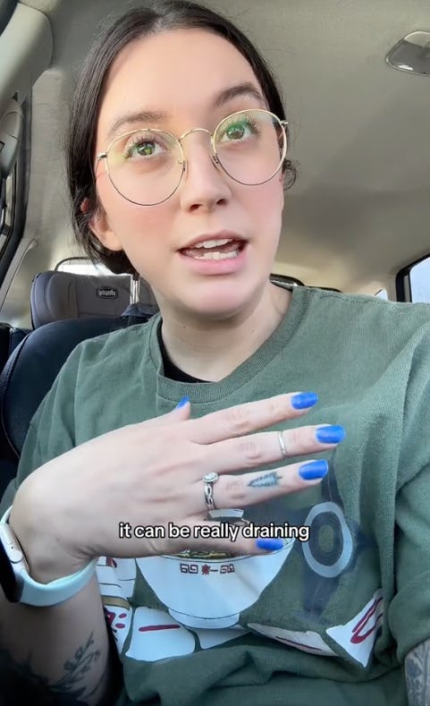 A person with glasses and blue nail polish gestures while speaking in a car, sharing thoughts about feeling drained. The caption emphasizes emotional fatigue.