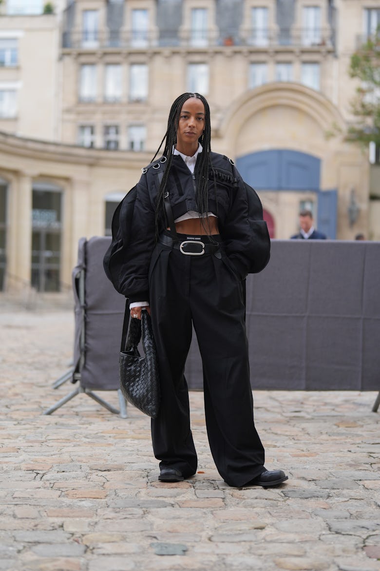 PARIS, FRANCE - SEPTEMBER 24: A guest wears white cropped buttoned up long sleeve shirt, black puffy...