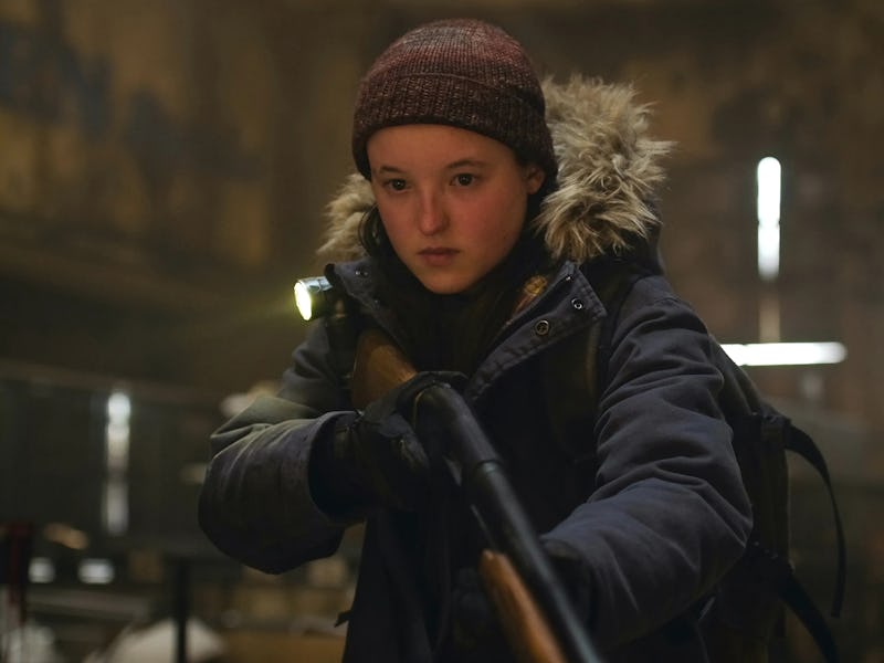 A young person in a winter jacket and beanie holds a rifle, looking determined in a dimly lit, aband...