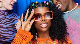 Young woman, who's most likely to be a witch based on her zodiac sign, holding her sunglasses.