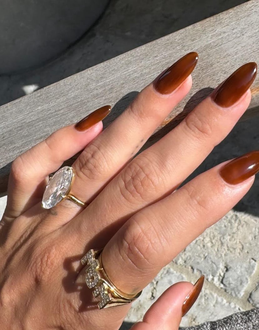 Hailey Bieber’s “toasted caramel” nail color and mom ring are a match made in heaven.