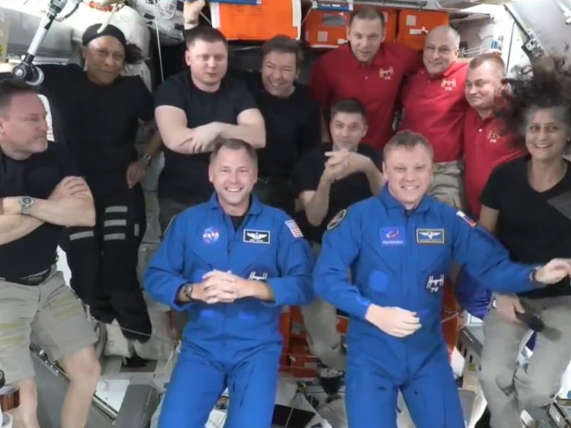photo of 11 people floating in a module of the International Space Station