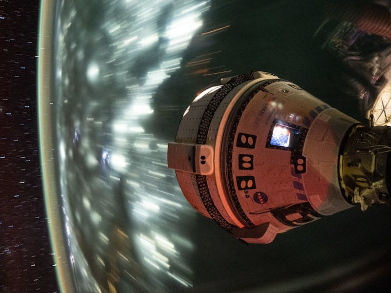 This long-duration photograph, which shows the Starliner capsule in space, was taken at night from t...
