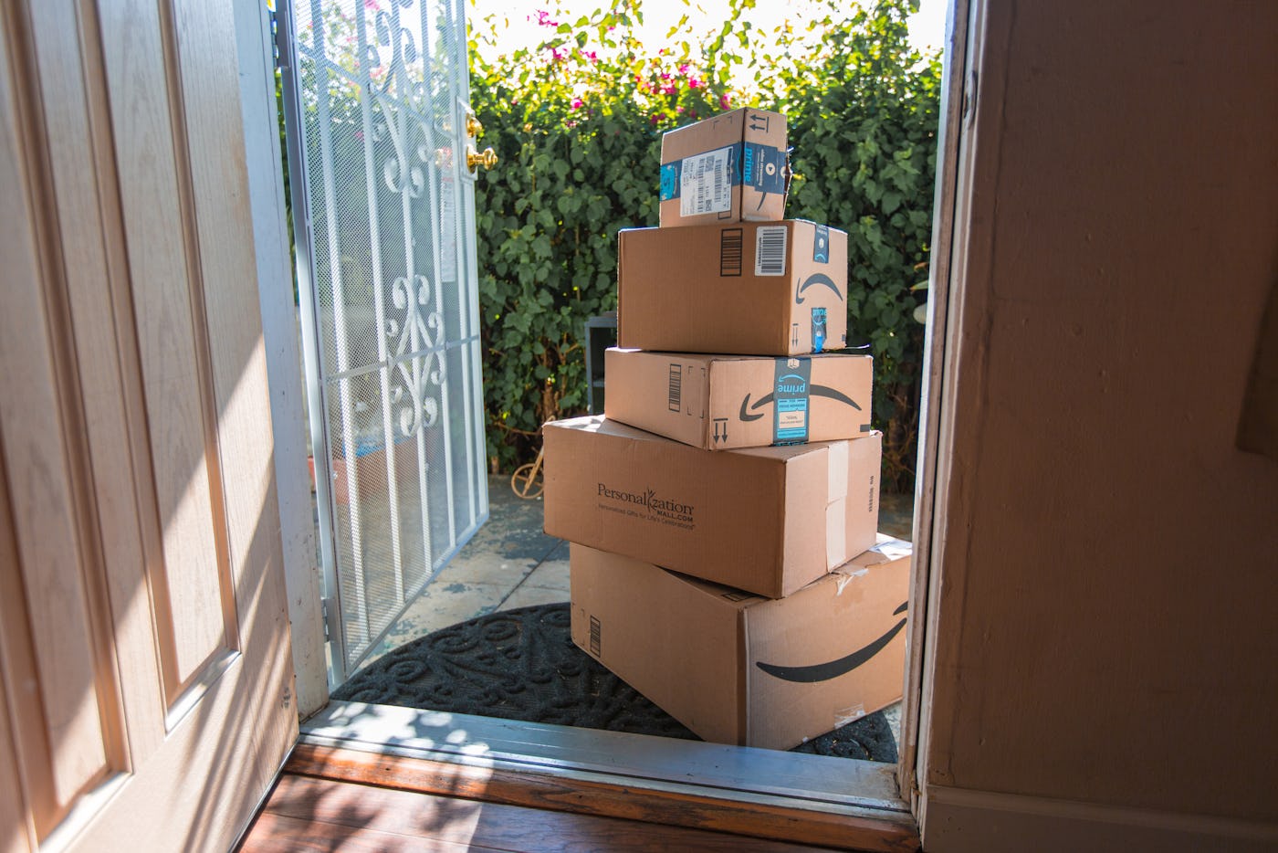 Image of an Amazon packages. Amazon is an online company and is the largest retailer in the world. Cardboard package delivery at front door during the holiday season. shipping package parcel box on wooden floor with protection paper inside. Amazon.com went online in 1995 and is now the largest online retailer in the world.