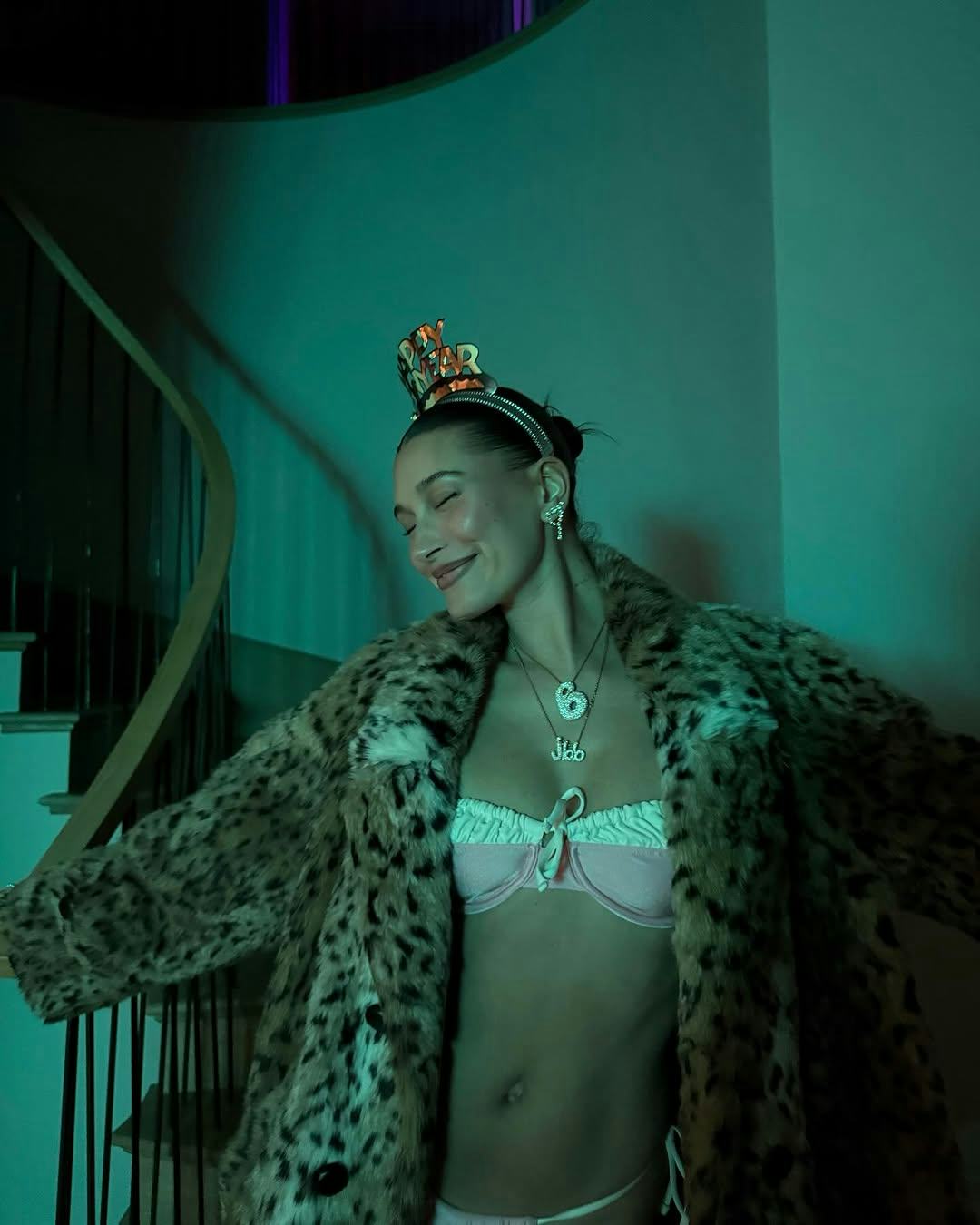 Hailey Bieber wears a pink bikini with a fur coat.