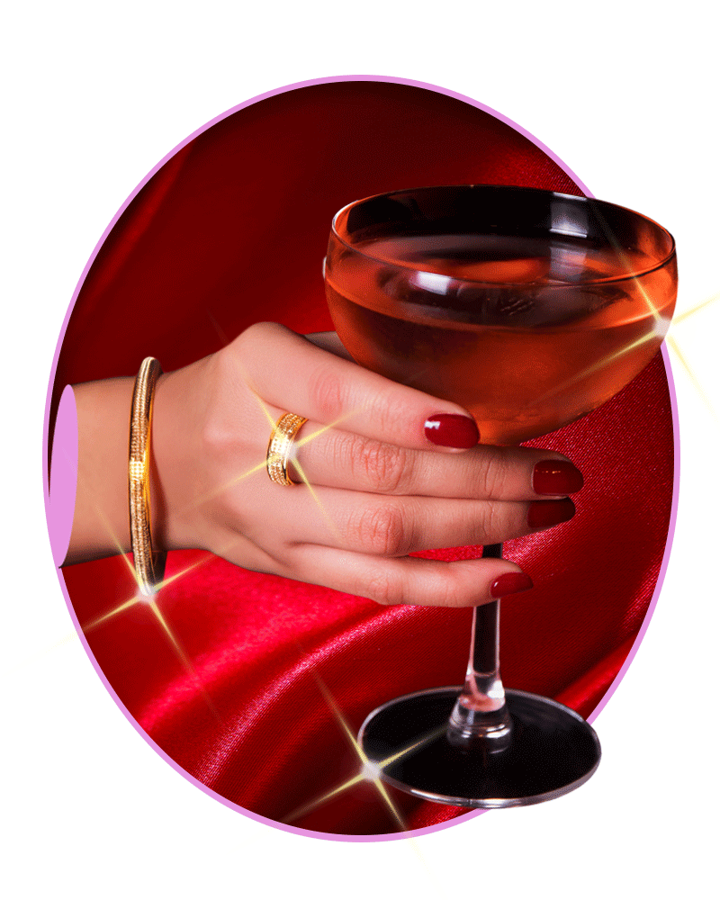 A hand holds a cocktail.