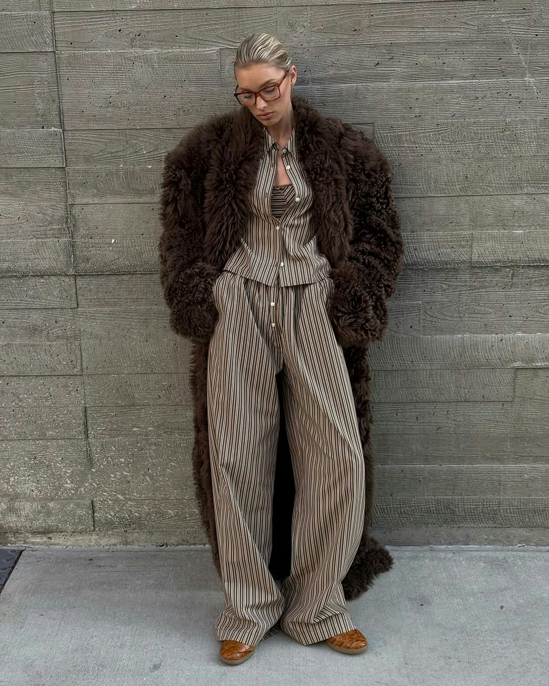 Elsa Hosk wears striped pajamas, a bra, and a fur coat.