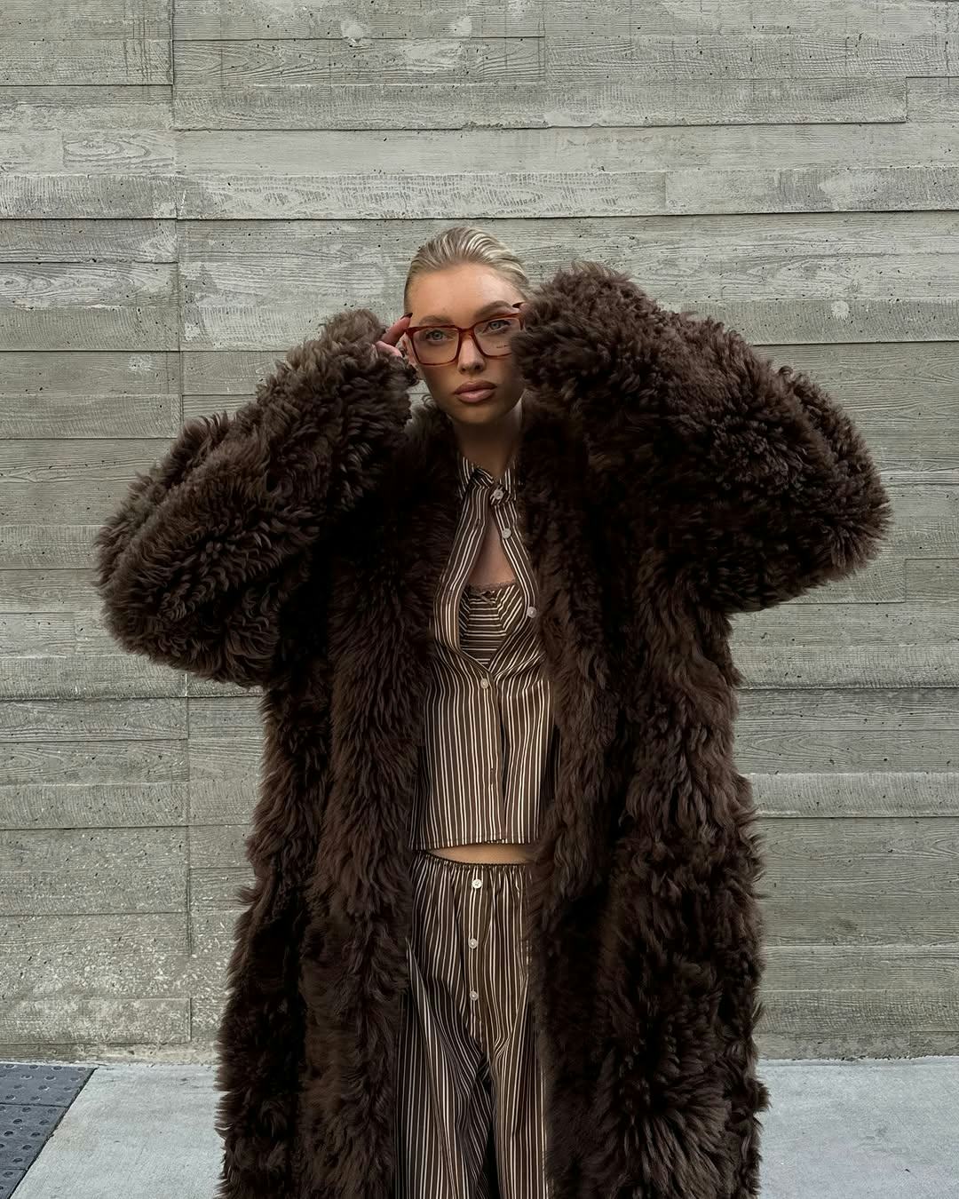 Elsa Hosk wears striped pajamas, a bra, and a fur coat.  