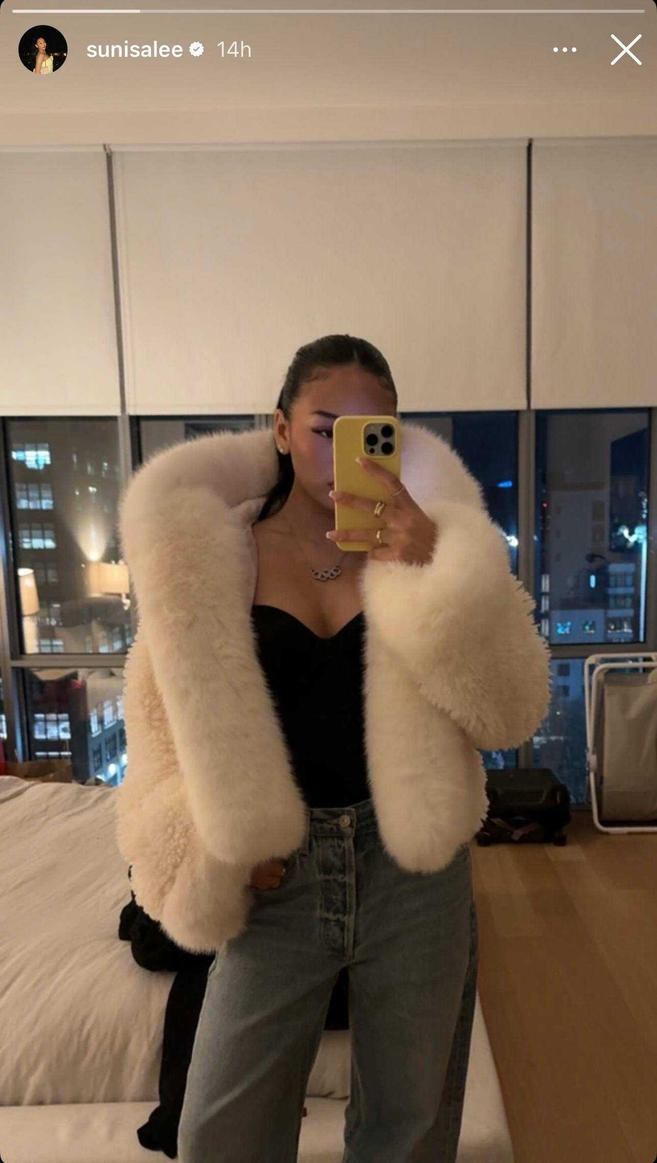 Suni Lee wears a faux fur white coat.
