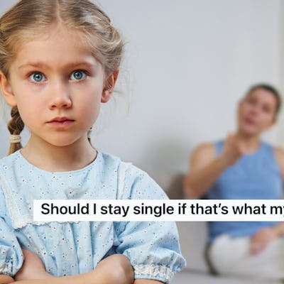 A concerned young girl with blue eyes crosses her arms, looking at the camera while a woman sits in the background, seemingly in discussion.