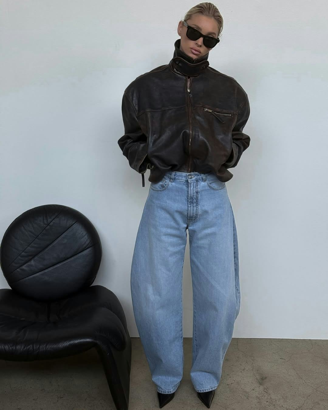 Elsa Hosk wears a leather jacket with barrel-leg jeans.