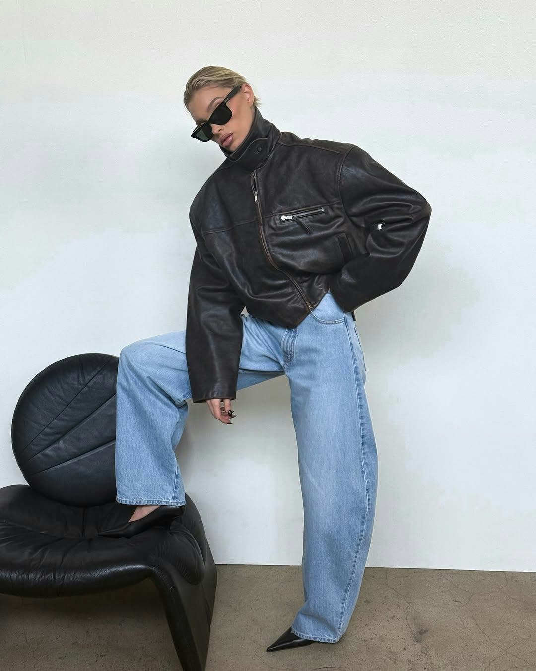 Elsa Hosk wears a leather jacket with barrel-leg jeans.