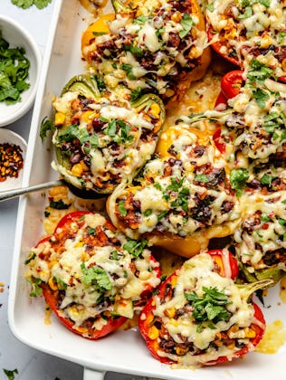 Vegetarian stuffed peppers in a baking dish, in a story about affordable bean recipes for dinner.
