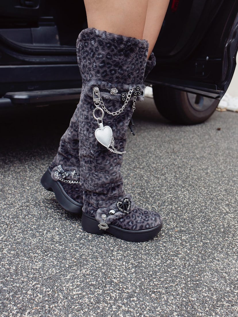 Millie Bobby Brown wears fur boots.