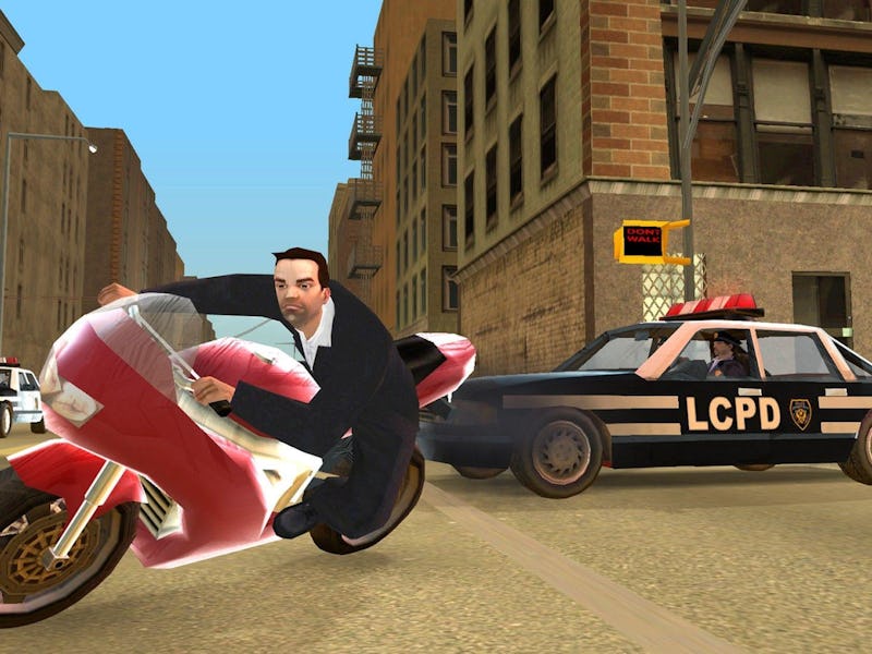 A man on a red motorcycle leans into a turn on a city street while two police cars labeled "LCPD" fo...