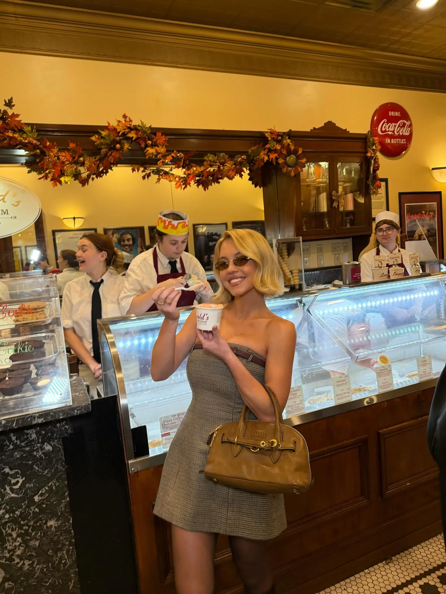 Sydney Sweeney wears a strapless mini and Miu Miu bag. 