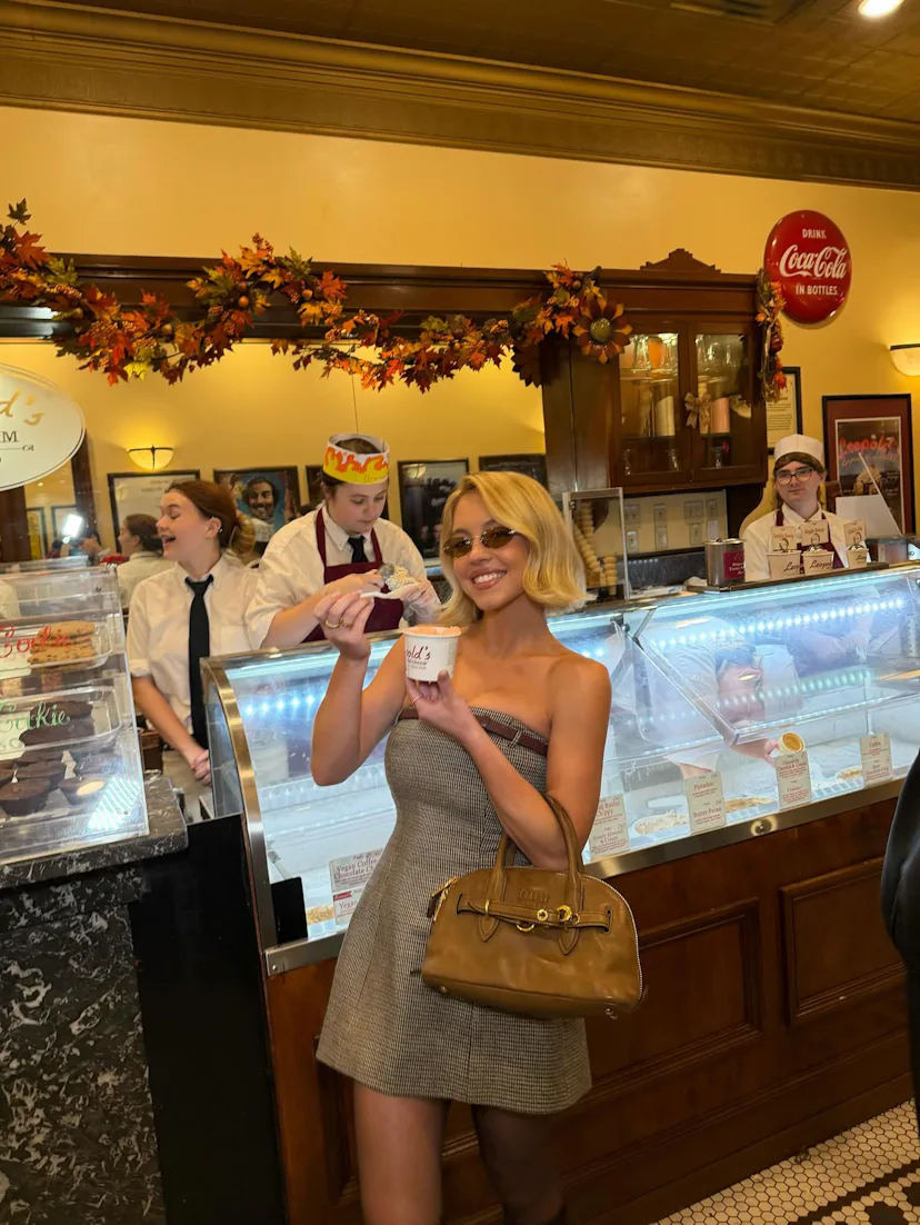 Sydney Sweeney wears a strapless mini and Miu Miu bag.