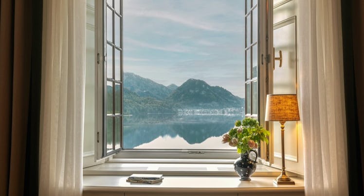 A room at the Rosewood Schloss Fuschl overlooking a lake and mountains