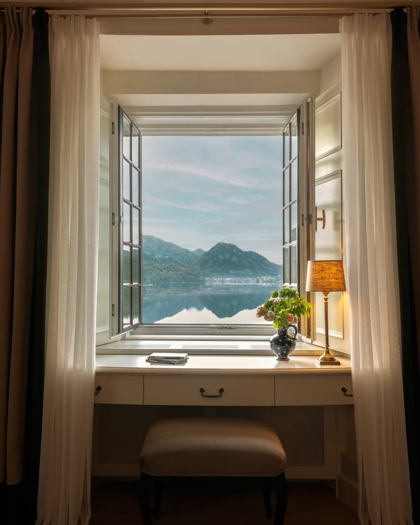 A room at the Rosewood Schloss Fuschl overlooking a lake and mountains