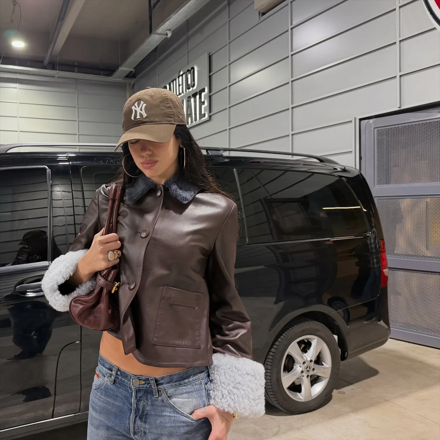 Dua Lipa wears a leather jacket and low-rise jeans. 