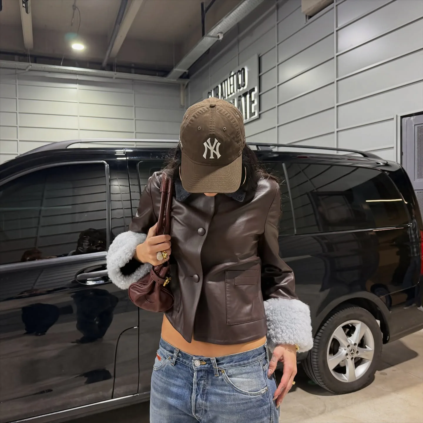 Dua Lipa wears a leather jacket and low-rise jeans.