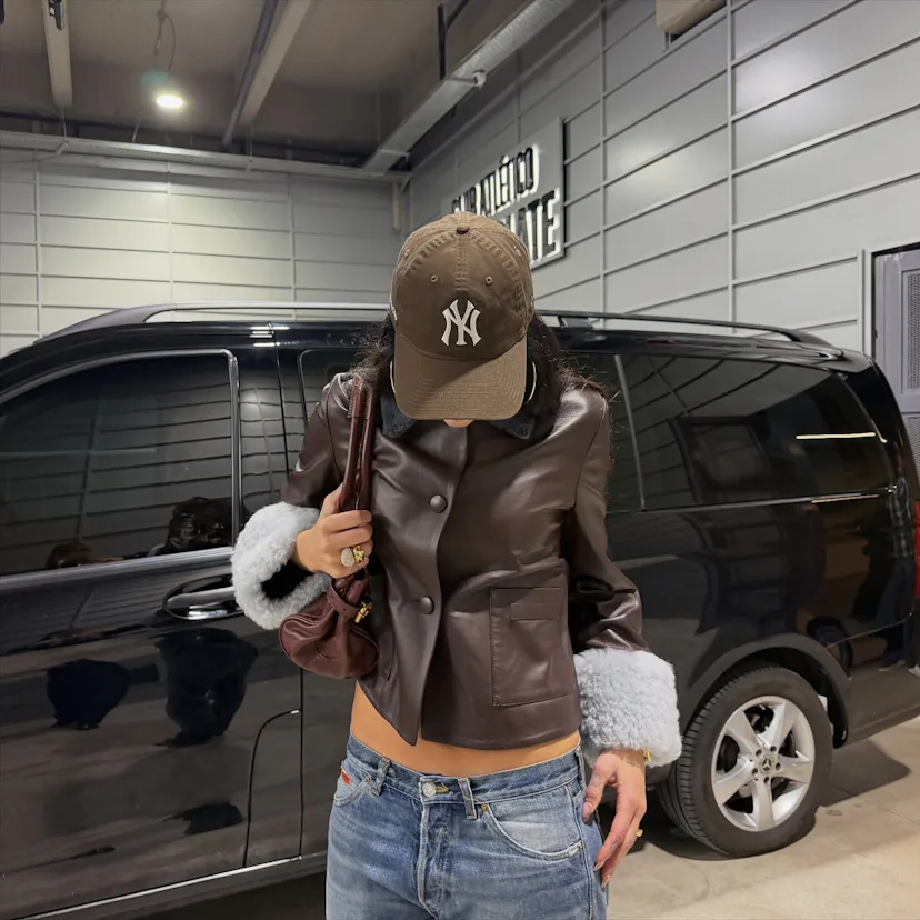 Dua Lipa wears a leather jacket and low-rise jeans.