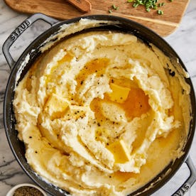 mashed potatoes in a pot with butter, in a story about inexpensive thanksgiving side dish recipes.